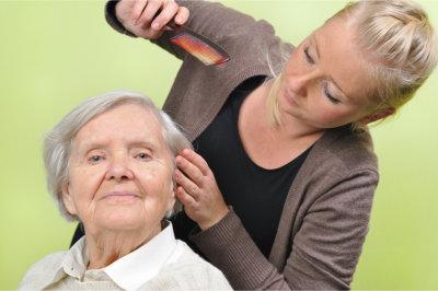 Caregiver combing a senior woman's hair