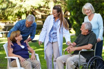 Caregiver chatting with two seniors